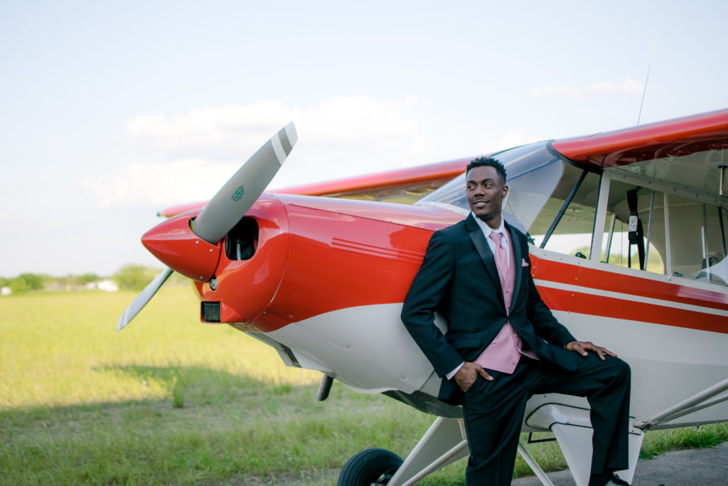 Male model poses with a small airplane
