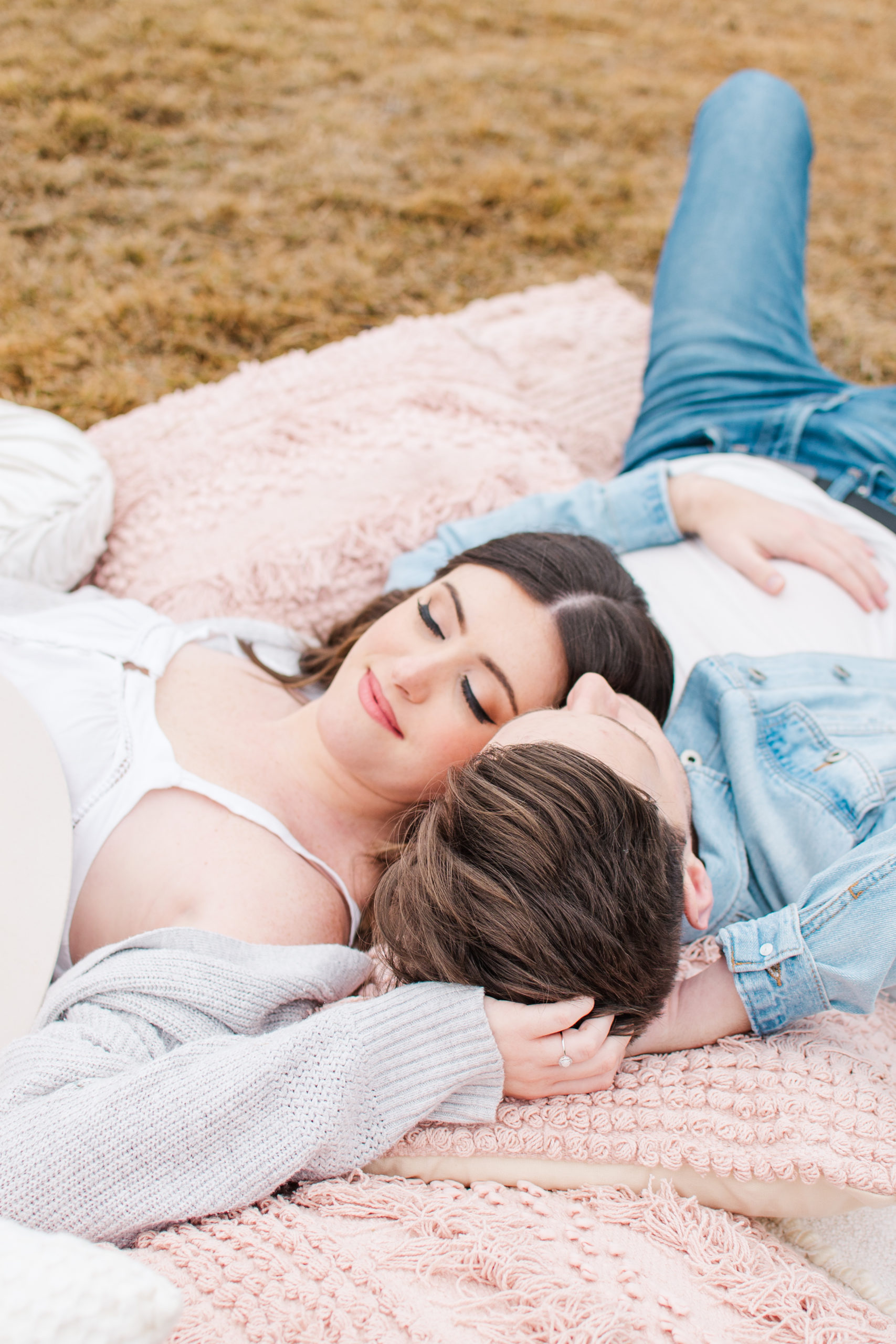 Picnic Engagement Photos where couple is lying on a picnic blanket