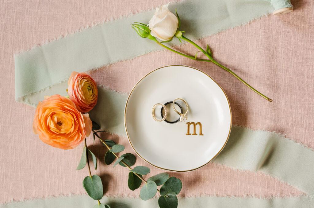 Wedding rings in a ring dish with bright pink and peach florals