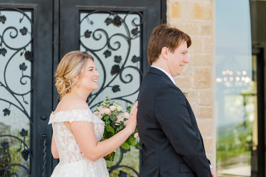 Bride taps groom on back for their first look at their Texas vineyard wedding
