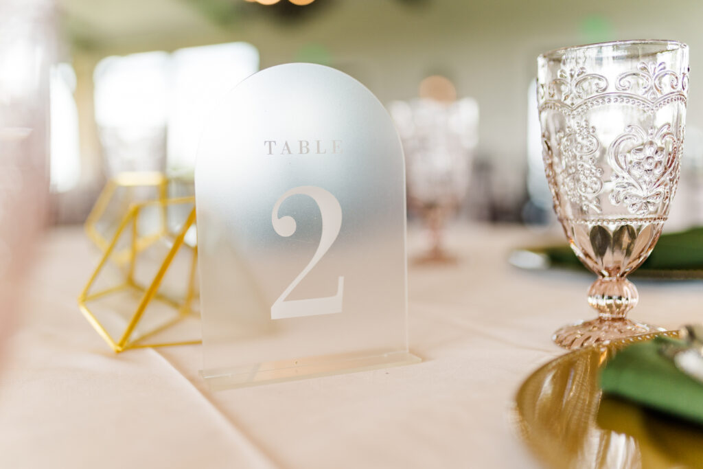 Table numbers on opaque acrylic letter boards on tables at a Texas vineyard wedding