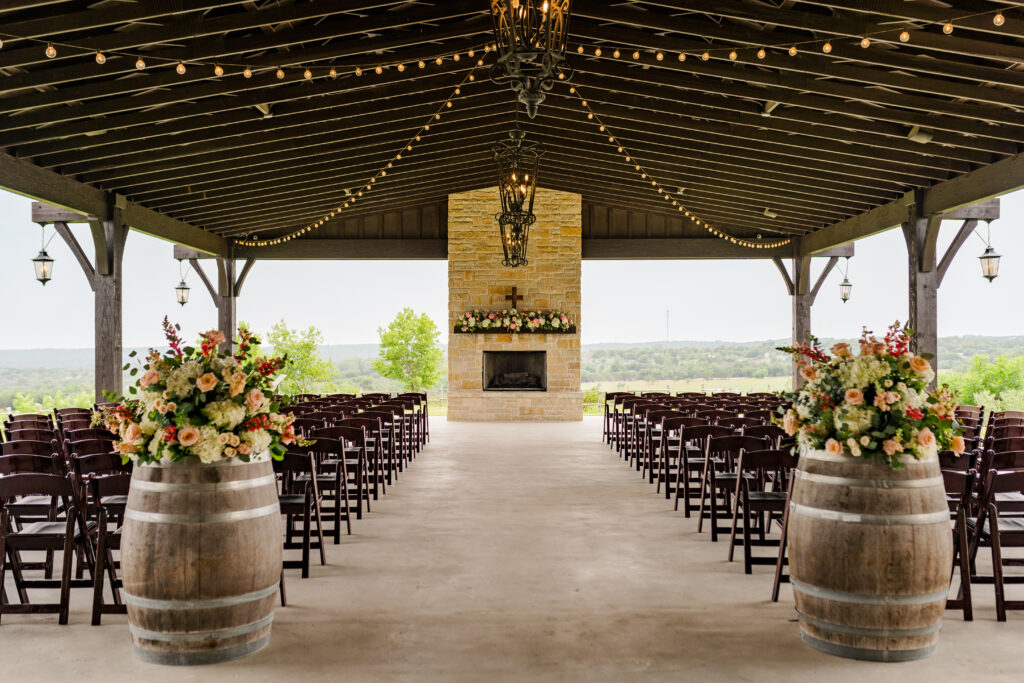Dove Ridge Vineyard Texas vineyard wedding ceremony setup with two wine barrels adorned with florals